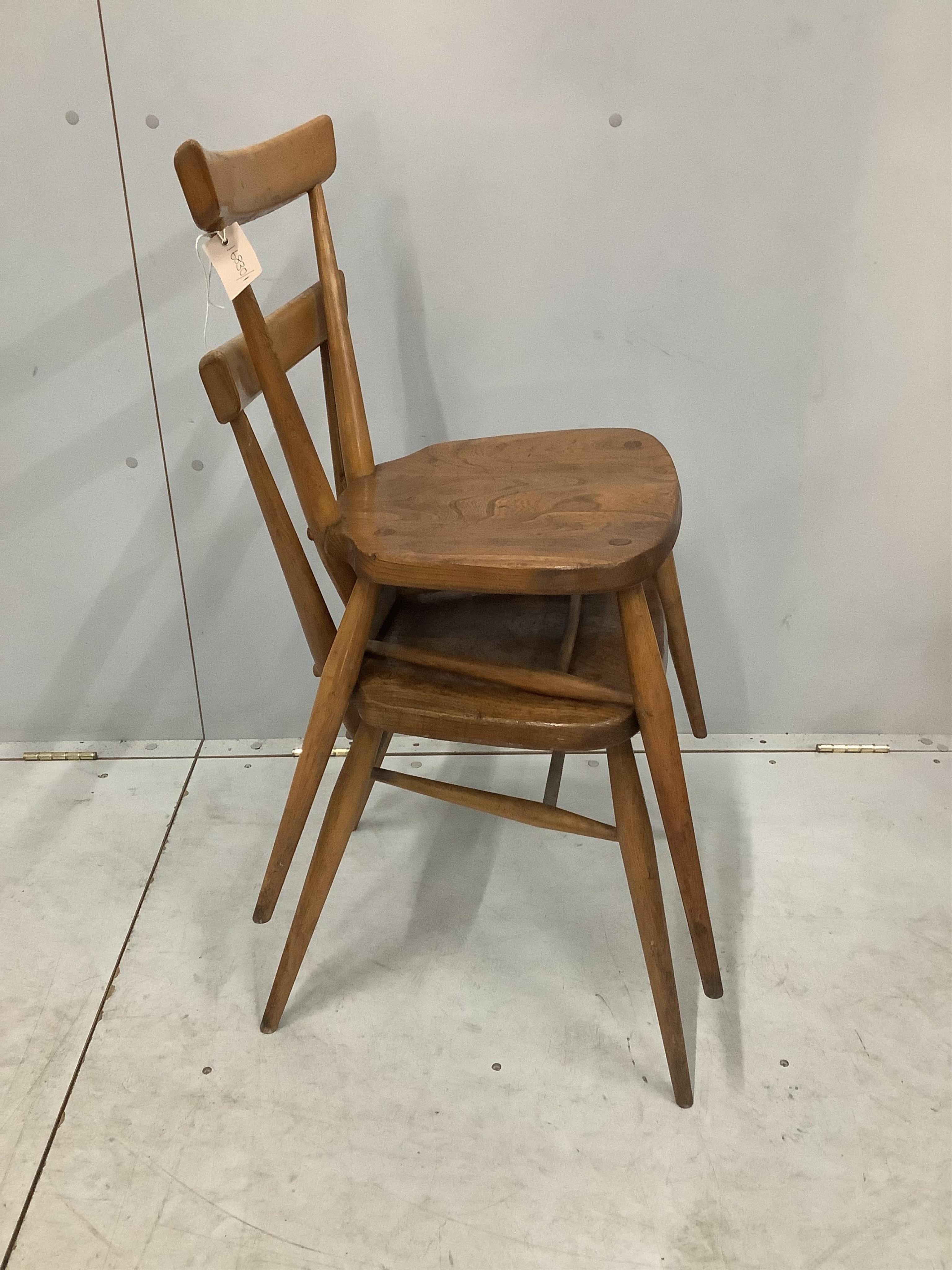 A pair of mid century Ercol elm and beech stacking chairs, width 39cm, depth 35cm, height 76cm. Condition - fair